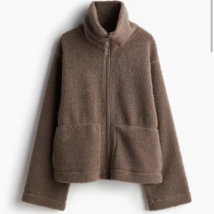 Brun teddyjacka med dragkedja H&M - Mysig brun teddyjacka med hög krage och dragkedja framtill. Jackan har två stora fickor och är perfekt för kyliga dagar. Den har en avslappnad passform och är långärmad. Hör av er vid intresse ❣️❣️