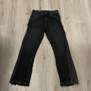flared jeans från Zara - Snygga svarta jeans från Zara med fransiga kanter. De har en klassisk femficksdesign och en rak passform. Perfekta för en avslappnad stil.