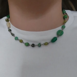 Färgglatt halsband med pärlor - Säljer ett unikt halsband med pärlor i olika gröna och gula nyanser. Halsbandet har en dekorativ låsdetalj och är perfekt för att ge en färgklick till din outfit. 🌹