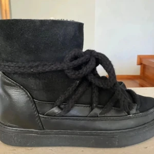 Svarta boots inuikii - Snygga svarta boots med snörning och rund tå. Skorna har en kombination av skinn och mocka vilket ger dem en stilren look. Perfekta för kyligare dagar.