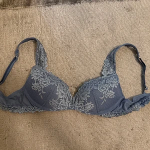 Blå spets-bh - Säljer en elegant blå bh med vacker spetsdetaljering från Intimissimi . Bh:n har justerbara axelband och en fin blommig spetsdesign som ger en romantisk känsla. Perfekt för att känna sig extra fin under kläderna. Storlek 75b använd en gång säljes då en var för liten. Nypris 500 kr mitt pris 370 kr