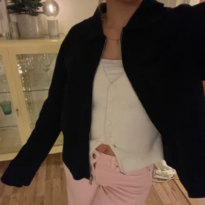 Marinblå jacka från Åhléns - Säljer en stilren marinblå jacka från Åhléns. Jackan har en enkel design med dragkedja och fickor framtill och långa ärmar. 