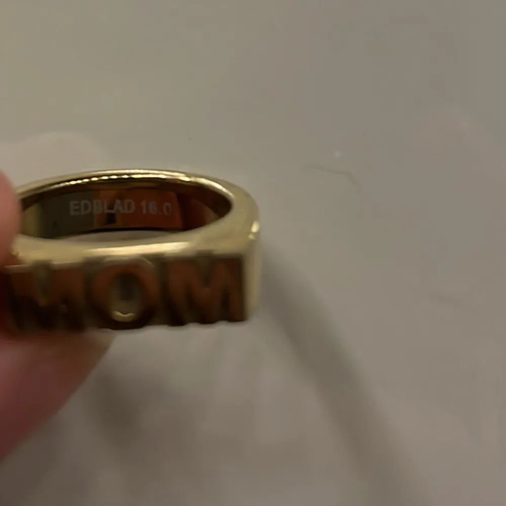 Snygg guldfärgad ring med texten 'MOM' i stora bokstäver. Perfekt som en personlig present eller för att visa uppskattning. Ringen har en modern och stilren design. Skriv för egna bilder❤️❤️Orginal pris - 399kr. Asusteet.