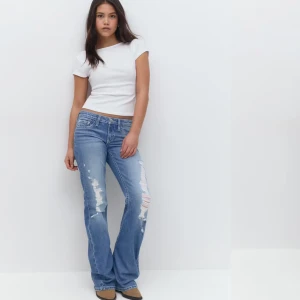 bootcut jeans med slitningar  - Snygga blå bootcut jeans från Gina med slitningar på framsidan. Aldrig använda och prislappen är kvar. 