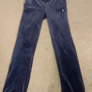 Mörkblå velourbyxor från Juicy Couture - Snygga mörkblå velourbyxor från Juicy Couture med text på baksidan. Byxorna  är knappt använda och är i toppskick! Skriv om du har frågor 💕💕