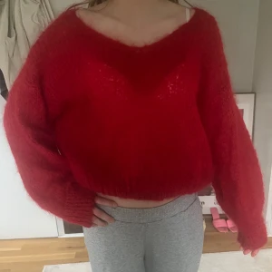 Röd stickad tröja från Americandreams - Supermjuk och fluffig röd stickad tröja från Americandreams. Nästintill helt oanvänd. Tröjan har en v-ringning och lång ärm. 