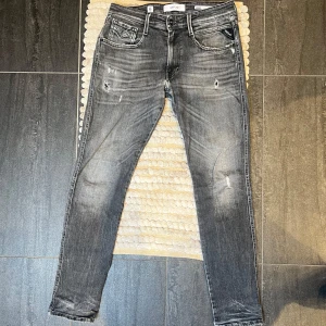 Replay Anbass Aged 5 years Jeans - Snygga jeans från Replay || Modell: Anbass Aged 05 years || Storlek: W31 L32 || Eftertraktad slutsåld modell || Fint skick förutom slitningar i grenen, ett litet hål - se bild 