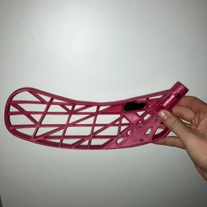 Innebandyblad i vinröt plast optilight - Säljer ett vinröt innebandyblad med öppet rutmönster och förstärkning i svart kolfiber. Bladet är böjt och har en modern design som passar för snabba skott och passningar. Perfekt för dig som vill ha ett lätt och stilrent blad till klubban. Kan gå ner i pris inte användt något. Right blad