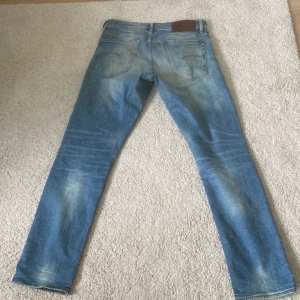 G-Star RAW 3301 Straight jeans - Säljer ett par ljusblå G-Star RAW 3301 jeans med straight fit. Klassisk femficksmodell med slitningar och tydliga tvättade partier. Jeansen har normal passform och raka ben, perfekt för en avslappnad stil.