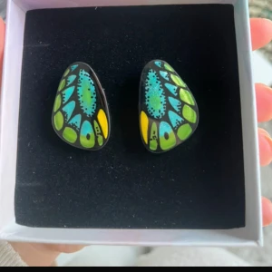 Färgglada örhängen med fjärilsmönster - Säljer ett par så coola örhängen med påfågel färger! Helt oanvända🩷
