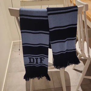 Blå och ljusblå halsduk med DIF-tryck - Säljer en halsduk i mörkblått och ljusblått med DIF-tryck och fransar i ändarna. Priset är inte hugget i sten, så tveka inte att höra av dig.
