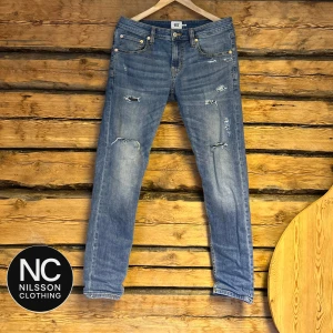 jeans med slitningar - Snygga grå/blå slim jeans med slitningar för en trendig look. De har en klassisk femficksdesign och är perfekta för en avslappnad stil. Passar bra till sneakers och en t-shirt. Jag är 175-180 och dem passar perfekt 