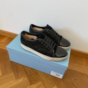 Lanvin skor  - Hej säljer mina lanvin skor i väldigt bra skick! Det ända som är defekt är lite uppkört i innehälen som inte syns elle märks av vid användning men går och fixa lätt hos skomakare! Har inte tvättat så noga nu men om man tar bort de lilla smutset på dem vita ute sulorna ser dem helt nya ut. Skorna är lite grå svarta och boxen med kommer. Hör av dig om frågor osv 