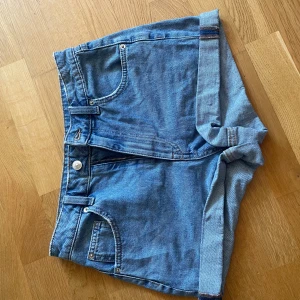 Blå jeansshorts från H&M Divided - Klassiska blå jeansshorts från H&M i storlek 36. Shortsen har normal passform och är tillverkade i bomull. Perfekta för sommaren och enkla att matcha med olika toppar. Mycket bra skick, nästan aldrig använda!💙