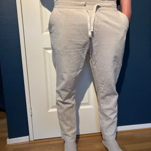 Beiga linnebyxor från Zara med snörning - Säljer ett par beiga linnebyxor från Zara i storlek L. Byxorna har snörning i midjan, sidofickor och bakfickor. De är raka i modellen och perfekta för en avslappnad stil.