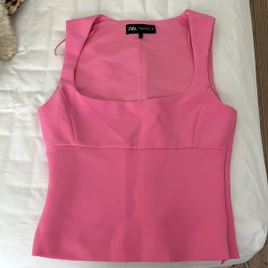 Rosa ärmlös topp från Zara - Säljer en snygg rosa topp från Zara i storlek XS. Toppen är ärmlös med breda axelband och har en fyrkantig urringning. Passar också S