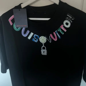 Louis Vuitton T-Shirt - Säljer en unik och fin Louis Vuitton T-Shirt som har det fina LV emblet på kragen, sitter perfekt i strl M. För fler funderingar tveka inte att höra av dig, priset är ej heller hugget i sten. Tags medföljes och den är oanvänd! Möts även i sthlm.