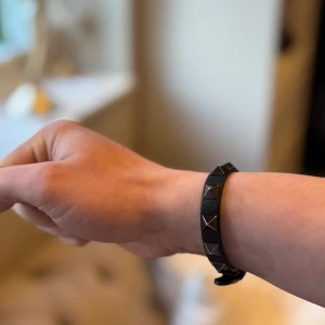 Svart armband från Valentino - Elegant svart armband från Valentino med nitar. Kommer i originalförpackning med dustbag och certifikat. Perfekt för att ge en edgy touch till din stil. Ställ Gärna Frågor!‎ ‎ obs det är lite slitet på insidan