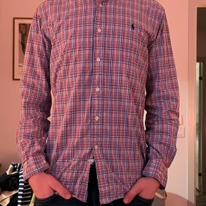 polo Ralph lauren skjorta - Säljer en klassisk rutig skjorta från Ralph Lauren i färgerna röd, blå, grön och vit. Skjortan har lång ärm, knappar framtill och broderad logga på bröstet. Modellen är Classic Fit och passar perfekt till dig som gillar en tidlös stil. Ny pris är cirka 1350. Mitt pris är endast 250kr. Skjortan är storlek S men funkar även bra för storlek M