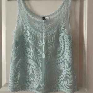 Broderad linnetopp - Superfin  linnetopp med broderade blommönster och transparent material. Perfekt för sommardagar och ger en fräsch look till din outfit.