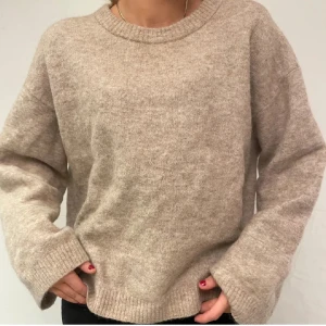 Beige stickad tröja från Arket - Mysig beige stickad tröja från Arket. Perfekt för kyliga dagar med sin mjuka och varma känsla. Tröjan har en rund hals och långa ärmar, vilket gör den idealisk för lager-på-lager-stil. Ett måste i garderoben för höst och vinter! Ok skick! Skriv privat för egna bilder, kan gå ner i pris via snabbaffär💕