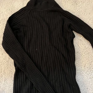 Svart ribbad polotröja från Cubus - Säljer en svart ribbad polotröja från Cubus i storlek M. Tröjan har lång ärm och är tillverkad i ett mjukt, stretchigt material som sitter snyggt på kroppen. Perfekt basplagg till garderoben!