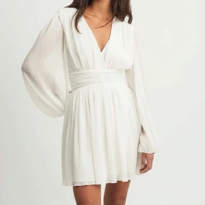 Structure flowy mini dress - Superfin vit klänning, perfekt för midsommar eller studenten!🙌🏻🎉 Från Lojsan Wallins kollektion med NAKD, aldrig använd och otroligt skön! Originalpris 650kr