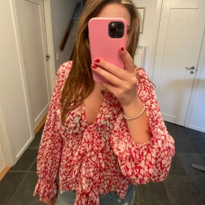 Rödvit blommig blus med knyt - Supersöt blus i rött från Zara. Knappt använd. Nypris 329kr pris går att diskuteras