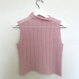 Rosa stickad ärmlös topp med hal polo 100% merinolammull - Topp i 100% supermjuk merinolammull som jag stickat på min stickmaskin. Garnet är såpass tunt att toppen blir otroligt lätt på kroppen. Du får de goda egenskaperna av ullen samtidigt som den inte blir för varm. Mycket stretchig i tyget. Uppskattad till strl S (Se mått för mer info kring passform)    Säljer billigt då jag så gärna vill att någon ska få glädje av den.   Garnet är kvalitetsmärkt med woolmark för merinoull. (Inköpt hos: Ankis design)