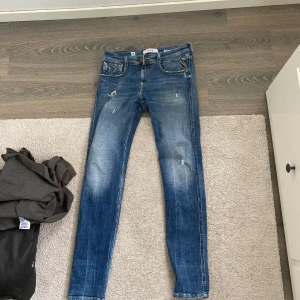 Blå Replay Anbass Jeans - Blå Jeans från Replay i modellen Anbass. Som nya använda ett fåtal gånger. Riktigt snygga med fina slitningar. Storlek: 30W 32L Skick:8/10