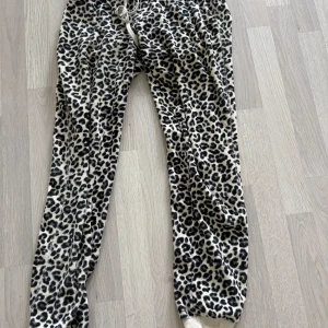 Leopardmönstrade mjukisbyxor - Leopardmönstrade mjukisbyxor med resår i midjan och benslut. Byxorna är i mjukt material och har en avslappnad passform. Perfekta för en chill dag hemma eller när du vill sticka ut lite extra. Använda 