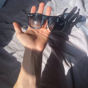  solglasögon från Ray-Ban BoyFriend - Klassiska svarta solglasögon från Ray-Ban med bred båge och mörka glas. Snygg och tidlös modell som passar till många stilar. Ray-Ban-loggan syns tydligt på linsen.