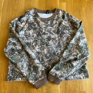 Camo tröja - Säljer denna feta tröjan som jag använt fåtal gånger. Den är cropped som ni ser på bilderna. Insidan är bomull vilket gör den väldigt mjuk och varm. Storlek S men den är lite oversized vid armarna.