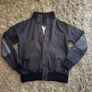 Tommy Hilfiger Cardigan: M - Säljer en super fin cardigan från Tommy Hilfiger i storlek M som har en skön Vintage look🥂. Tröjan sitter true to size. Den är o väldigt bra skick och perfekt för sommarkvällar eller som vår och höst jacka🍁 Hör av er vid fler funderingar😊