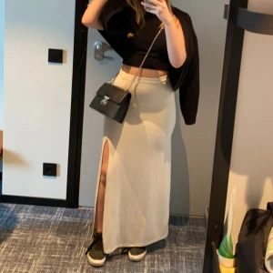Beige långkjol med slits - Säljer en beige långkjol med hög midja och slits framtill. Kjolen har en rak passform och är tillverkad i ett mjukt, stretchigt material som ger en snygg siluett. 💗