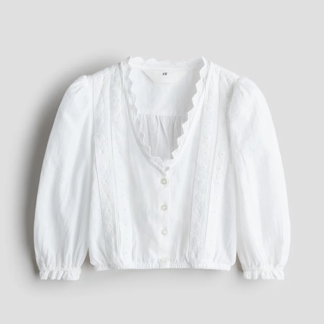 Vit blus med spetsdetaljer från H&M