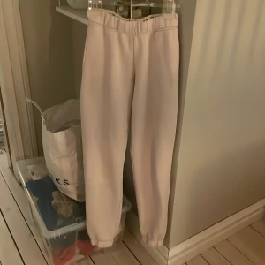 Ljusrosa mjukisbyxor från New Yorker - Säljer ett par ljusrosa mjukisbyxor från New Yorker i storlek XS. Byxorna har resår i midjan och vid bensluten för en bekväm passform. Perfekta för en avslappnad stil.