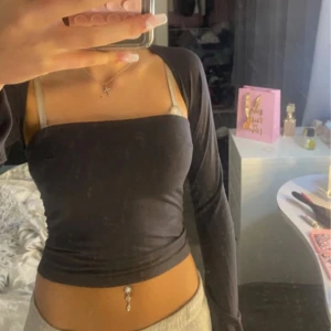 Svart croppad långärmad topp - Trendig svart croppad topp med långa ärmar och tight passform. Perfekt att styla med höga byxor eller kjol för en snygg look.