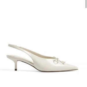 Vita slingback pumps med rosett och spetsig tå - Stilrena vita pumps med låg klack och öppen häl. Skorna har en elegant spetsig tå och en söt rosettdetalj framtill. Perfekta för dig som vill ha en klassisk och feminin look. Köpte för stor storlek och hann ta bort lappen så aldrig använda!💗 skriv för fler bilder! 😍
