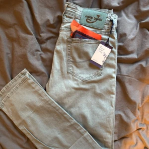 Oanvända Jacob Cohën Jeans - • Modell: 51210 - Slim Fit • Storlek: W34 - L34.      • Färg: Ljusblå blandat med nyanser av grön (ljusgrönblåa) • Skick: Helt Nya!, alla tags kvar.      • Nypris: 4500kr +++ • Mitt pris: 2099kr ✅           • Skickar inom 48 timmar 📦                                                                               Skriv kring funderingar ✅✅✅👍👍👍.       