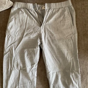 Ljusgrå linne/bomull byxor - Säljer ett par ljusgrå linne/bomulls byxor med normal passform i jättefint skick! Perfekta nu inför sommaren och en klassisk stilren look. Hör av er vid frågor eller prisförslag.