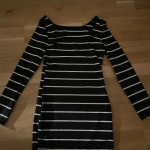 Svart och vit randig klänning från SHEIN - Säljer en svart klänning med vita horisontella ränder från SHEIN. Klänningen har lång ärm och är tillverkad i mjuk polyester. Snygg och enkel design som passar perfekt till många tillfällen.