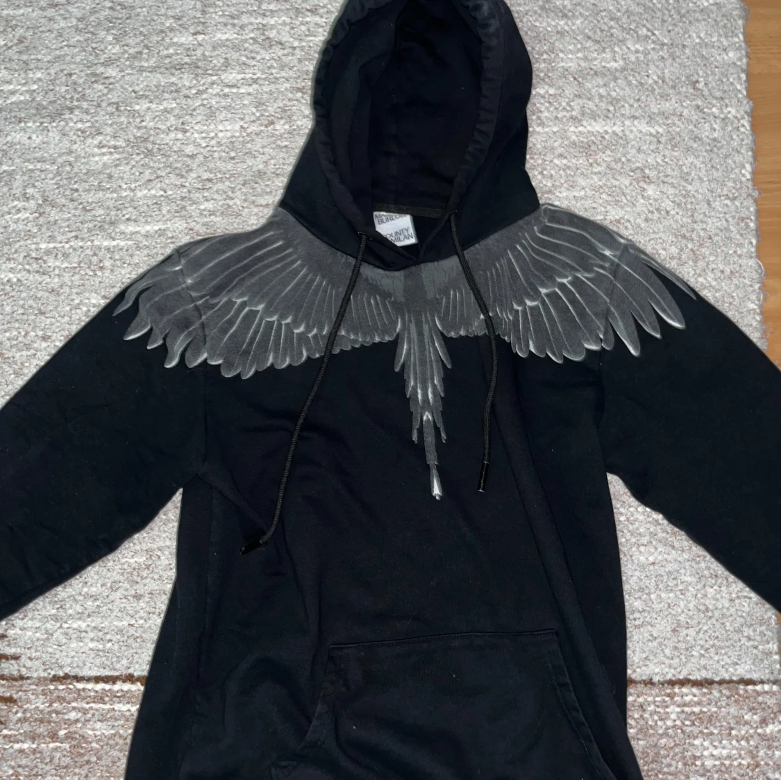 Svart hoodie med vingmönster från Marcelo Burlon