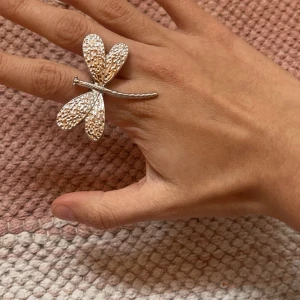  silverfärgad ring med trollslända - Unik och iögonfallande ring i form av en trollslända i silverfärg. Ringen har detaljerade vingar och en lång kropp som täcker två fingrar. Perfekt accessoar för dig som vill sticka ut.
