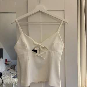 Zara topp - Säljer denna jättesöta slutsålda toppen med rosetter och öppning framtill!! Aldrig använd så den är i nyskick(därav priset), prislappen är kvar❤️