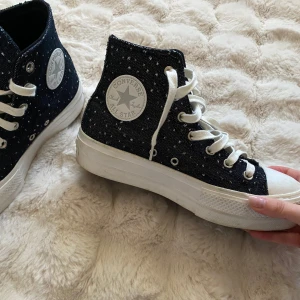 Svarta glittriga  Converse - Säljer ett par glittriga svarta Converse. Kartongen och svarta skosnören följer med. Använda fåtal gånger. Går säkert att putsa upp den vita sulan. Så snygga men kommer tyvärr inte till användning. Stl 39. 