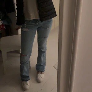 Ljusblå slitna jeans - Säljer ett par ljusblå jeans med slitningar på knä och lår. Jeansen har en rak passform och låg midja.
