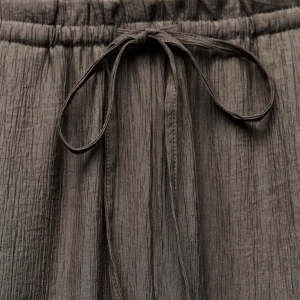 Bruna byxor med knyt i midjan - Säljer ett par bruna byxor i mjukt, krinklat tyg med resår och knytband i midjan. 