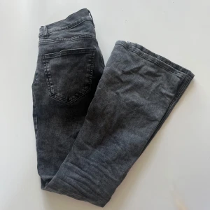 Grå/svart Jeans från Gina  - Säljer ett par grå/svart jeans från Gina tricot i klassisk femficksmodell. Jeansen har normal passform och är bootcut och låg midjade!