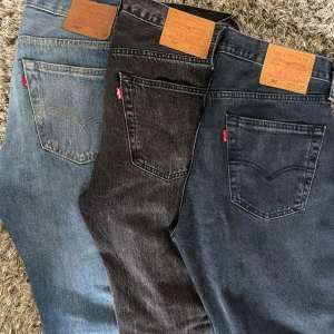 Levis 501 jeans i tre olika färger  - Tre par klassiska Levis 501 jeans i olika färger: ljusblå, svart och mörkgrå. Alla har raka ben och är så gott som nya. Storlek på alla jeansen är W31,L32. PRISET KAN DISKUTERAS!